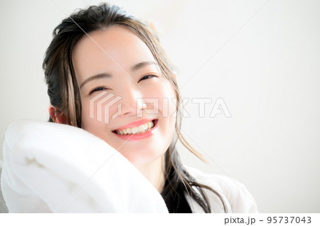 フワフワのタオルを顔に寄せる美しい女性 95737043