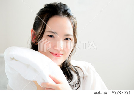 フワフワのタオルを顔に寄せる美しい女性 95737051