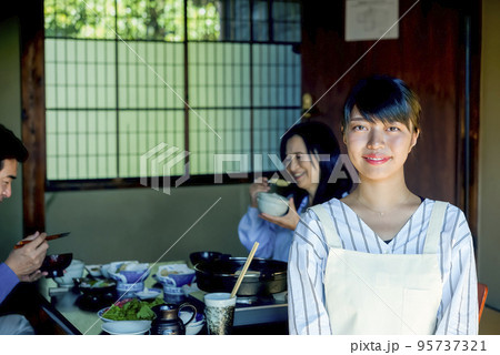 旅館　仲居さんと昼食を食べるシニアカップル 95737321