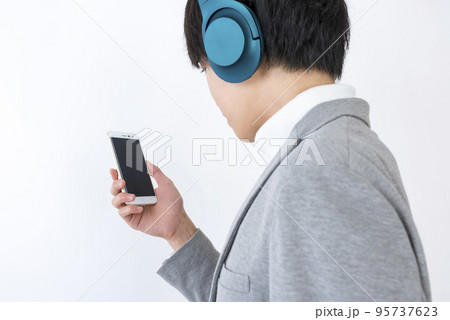 スマホで音楽を聴く若い男性 95737623