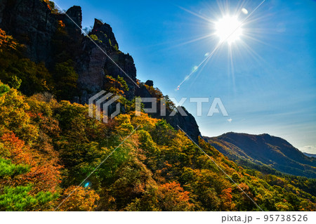 朝日を浴びる紅葉の山 95738526