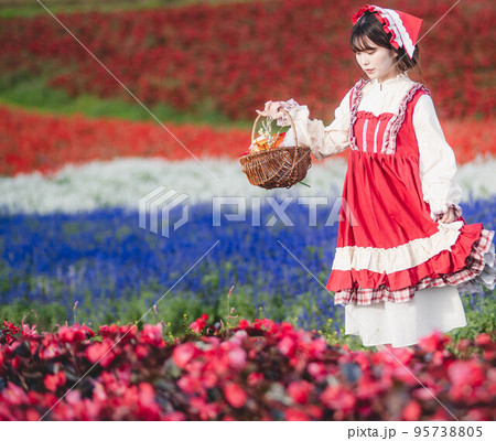 花畑の中で赤ずきんの格好をして楽しそうにしている女性 花畑の中で赤ずきんの格好をして楽しそうにしている女性 95738805