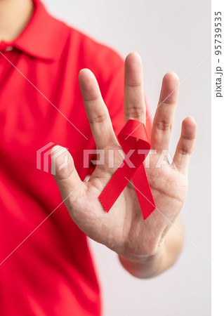 Red Ribbon for December World Aids Day, acquired immune deficiency syndrome, multiple myeloma Cancer Awareness month and National Red ribbon week. Healthcare and world cancer day concept Red Ribbon for December World Aids Day, acquired immune deficiency syndrome, multiple myeloma Cancer Awareness month and National Red ribbon week. Healthcare and world cancer day concept 95739535