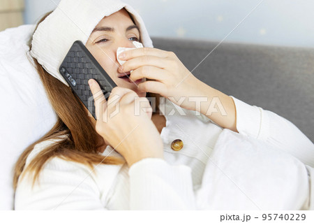 Sick woman with a runny nose calling the doctor for help and advice Sick woman with a runny nose calling the doctor for help and advice 95740229