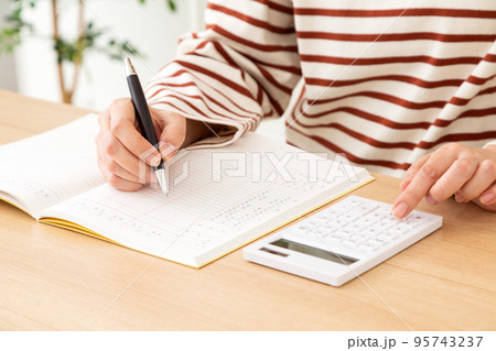 家計簿をつけるカジュアル姿のミドル女性 95743237