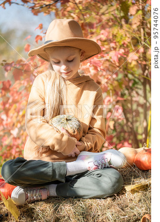 Girl in the hay with pumpkins Girl in the hay with pumpkins 95744076