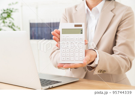 電卓を持つスーツを着たミドル女性 95744339