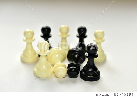 A group of chess pieces in white and black. 95745194