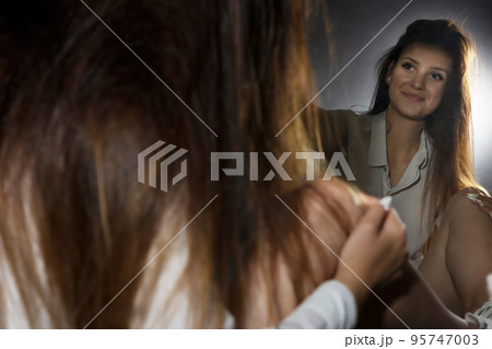 Young woman is sitting in front of the mirror Young woman is sitting in front of the mirror 95747003
