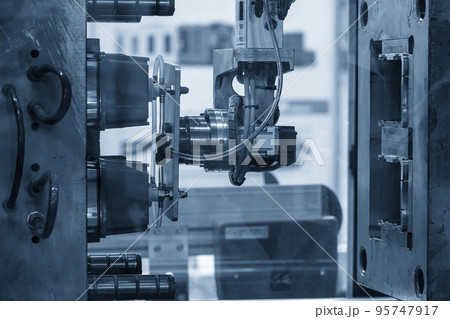 The robotic arm gripping the plastic cup from the injection machine. The robotic arm gripping the plastic cup from the injection machine. 95747917