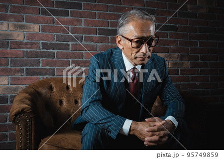 ソファに腰掛ける年配男性 ソファに腰掛ける年配男性 95749859