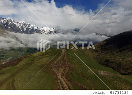 Ancient Gergeti Trinity Church high in the Caucasus mountains, aerial view. Georgia 95751182
