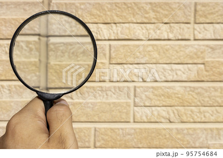外壁のコーキングを虫眼鏡で点検するイメージ 95754684