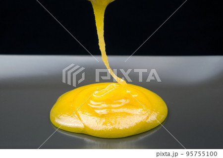 Fresh viscous floral honey flows onto the plate. vitamin organic food 95755100