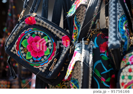 Black bag with colorful embroidery, close-up photo. 95756166