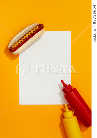 Classic hot dog with wurst, ketchup and mustard on orange background 95756604