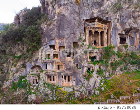 Antique rock burial chambers in Turkish village of Fethiye 95758039