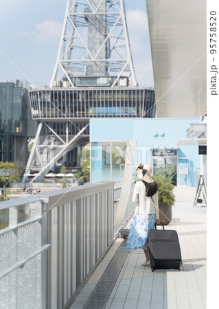 スーツケースを引いて名古屋観光をする若い女性 後ろ姿 95758520