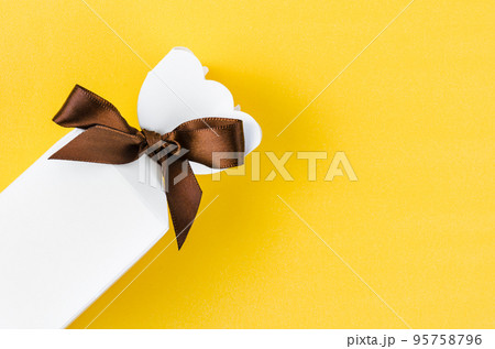 The gift box on light yellow background with copy space. The gift box on light yellow background with copy space. 95758796