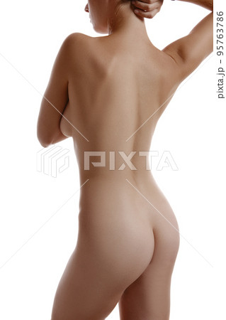 Nude woman covering her breast with hands, posing standing back to camera, isolated on white. Plastic surgery and aesthetic cosmetology. Close-up. Nude woman covering her breast with hands, posing standing back to camera, isolated on white. Plastic surgery and aesthetic cosmetology. Close-up. 95763786