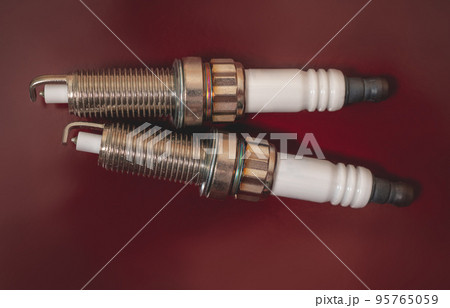 Spark plugs for a car on a dark background Spark plugs for a car on a dark background 95765059