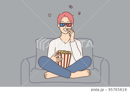 Smiling guy watching movie eating popcorn  95765619