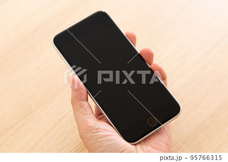 スマートフォンを持つミドル女性の手 95766315