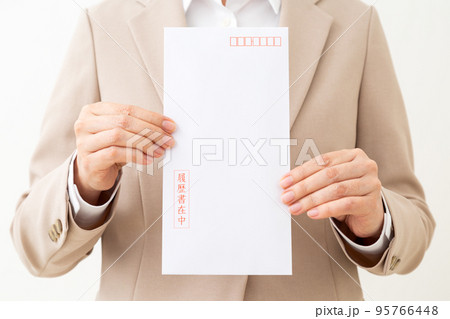 履歴書の封筒を持つスーツ姿のミドル女性 95766448