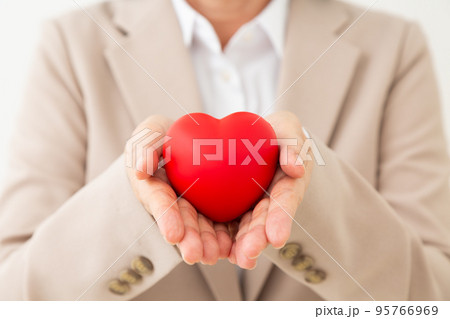 ハートを持つスーツ姿のビジネスウーマン ハートを持つスーツ姿のビジネスウーマン 95766969