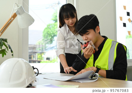 Team of architects and inspectors supervising progress of construction project together at office 95767083