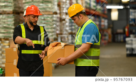 Irritated male manager expressing dissatisfaction with work of young intern in warehouse . Stress at work concept 95767093