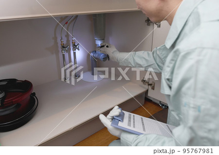 シンク下のチェックする作業服の男性 シンク下のチェックする作業服の男性 95767981