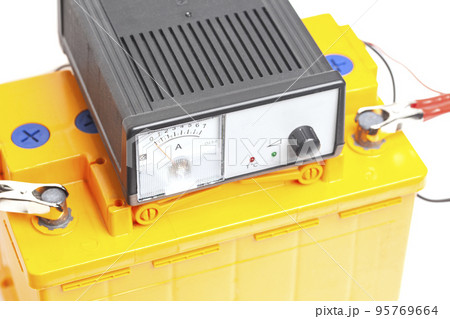 yellow car battery with car battery charger isolated on white background 95769664