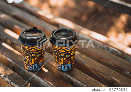 Background two glasses of takeaway coffee on wooden bench Background two glasses of takeaway coffee on wooden bench 95770352