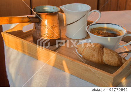 Cup of coffee, Turk, croissants on wooden plate closeup. Breakfast, Selective focus. 95770642