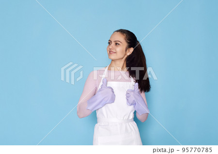 woman in gloves and cleaner apron showing ok sign 95770785