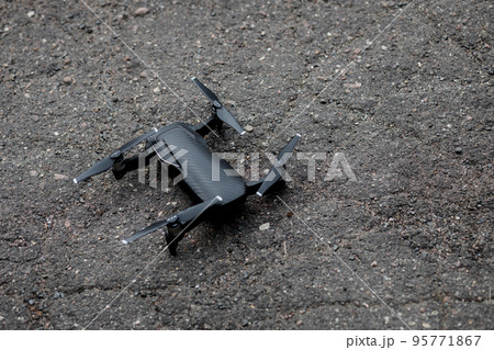black drone on asphalt. 95771867