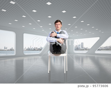scared businessman on a chair in office scared businessman on a chair in office 95773606