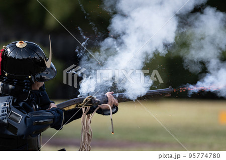 火縄銃を射撃する鎧武者 95774780