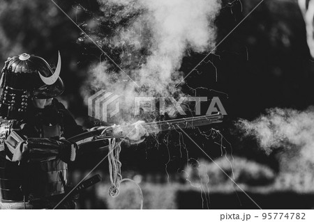 火縄銃を射撃する鎧武者 95774782