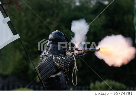 火縄銃を射撃する鎧武者 95774791