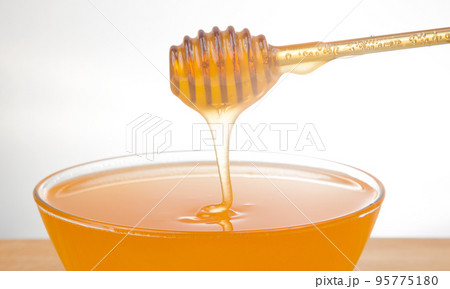 fresh fragrant honey drips from a spoon into a plate. organic vitamin nutrition. dessert food 95775180