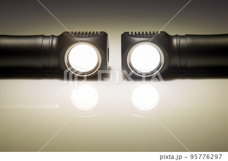 included light beams of different flashlights on a dark background. camping and household item. 95776297