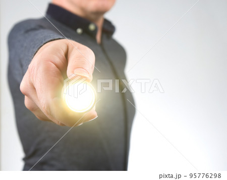 man holds a flashlight in his hand. item for camping and household life man holds a flashlight in his hand. item for camping and household life 95776298