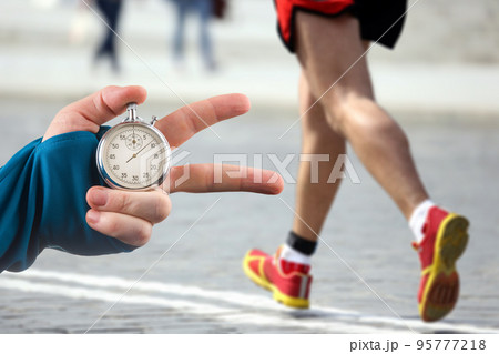 measuring the running speed of an athlete using a mechanical stopwatch measuring the running speed of an athlete using a mechanical stopwatch 95777218