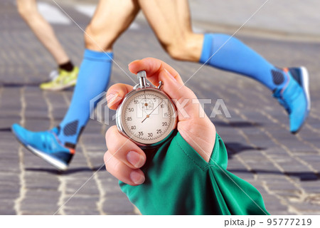 measuring the running speed of an athlete using a mechanical stopwatch 95777219