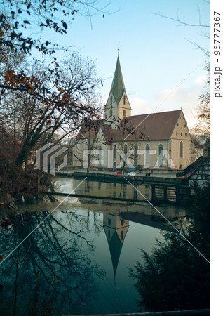 Rustic Hammermill roof reflected on the well Blautopf in the heritage town of Blaubeuren in Germany which is a popular tourist destination 95777367