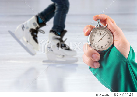 measuring speed on skates with a stopwatch. hand with a stopwatch measuring speed on skates with a stopwatch. hand with a stopwatch 95777424