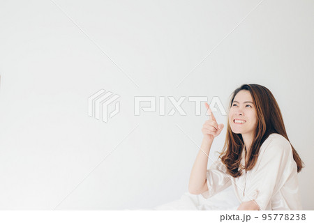Portrait of asian woman pointing at white background. Portrait of asian woman pointing at white background. 95778238