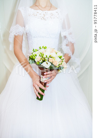 Beautiful wedding bouquet in hands of bride 95778411